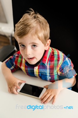 Little Boy Plays With Smartphone Stock Photo