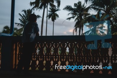 Little Boy Standing At A Balcony Looking Out Thinking Stock Photo