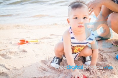 Little Cute Boy Playing Sand On The Beach Stock Photo