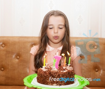 Little Girl Blowing Out The Candles On A Birthday Cake Stock Photo