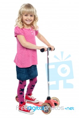 Little Girl Enjoying Her Toy Scooter Ride Stock Photo