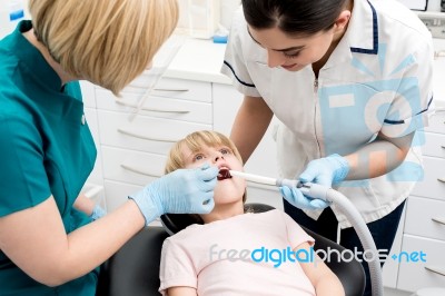 Little Girl Examined By Dentist And Her Assistant Stock Photo