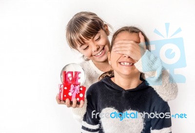 Little Girl Giving Surprise Love Gift To Her Friend With White Background Stock Photo