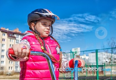 Little Girl In A Safety Helmet Riding A Bicycle Stock Photo