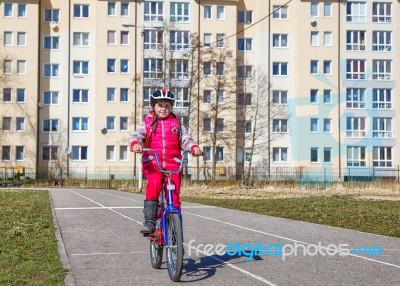 Little Girl In A Safety Helmet Riding A Bicycle Stock Photo