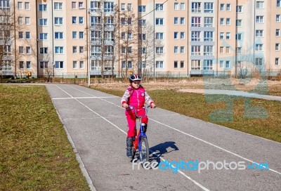 Little Girl In A Safety Helmet Riding A Bicycle Stock Photo