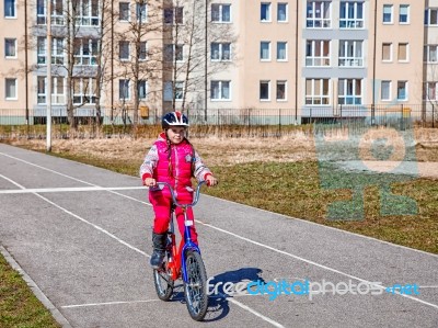 Little Girl In A Safety Helmet Riding A Bicycle Stock Photo