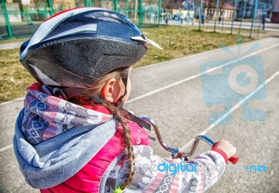 Little Girl In A Safety Helmet Riding A Bicycle Stock Photo