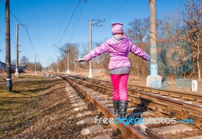 Little Girl Is Walking On Rails Stock Photo