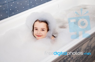 Little Girl Lying In A Bath With Soap Suds Stock Photo