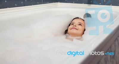 Little Girl Lying In A Bathtub Stock Photo