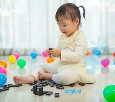 Little Girl Playing With Black Domino Stock Photo