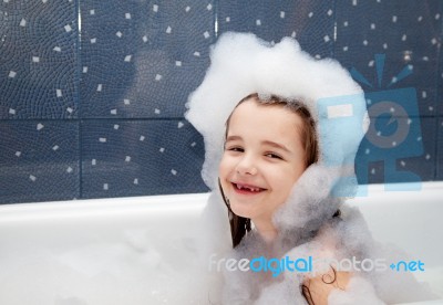 Little Girl Sitting In A Bath With Soap Suds Stock Photo