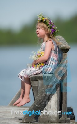 Little Girl With Flowers On A Bench Stock Photo