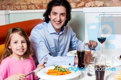 Little Girl With Her Father At A Restaurant Stock Photo