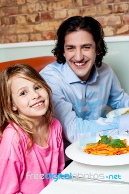 Little Girl With Her Father In Restaurant Stock Photo