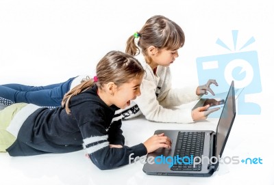 Little Girls Playing Games On The Notebook And Tablet Isolated On White Stock Photo