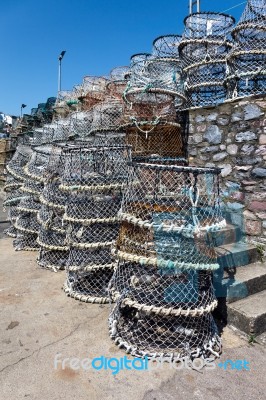 Lobster Pots Stacked Against The Harbour Wall In Brixham Stock Photo