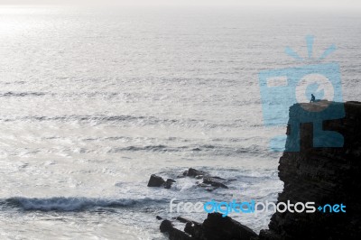 Lonely Man On Cliff Stock Photo