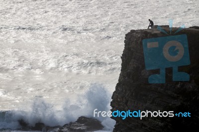 Lonely Man On Cliff Stock Photo