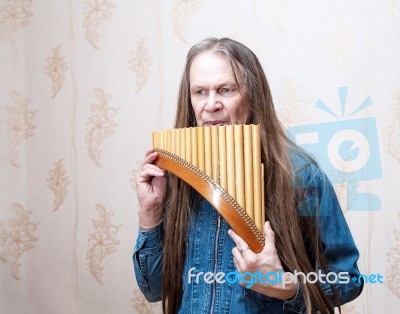 Long-haired Elderly Man With Pan Flute Stock Photo