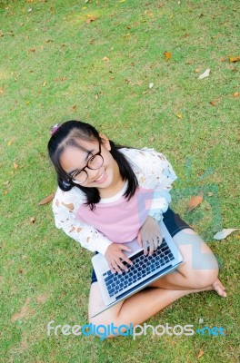 Lovely Girl With A Laptop On The Grass Stock Photo