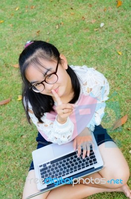 Lovely Girl With A Laptop On The Grass Stock Photo