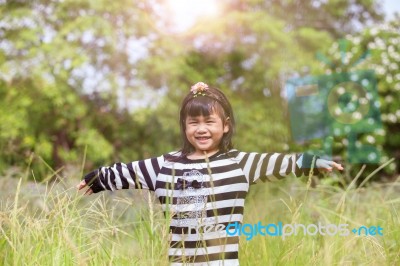 Lovely Kid Smiling Face With Happiness Emotion In Natural Green Field Stock Photo