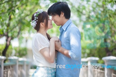 Loving Asian Couple Under Tree Stock Photo