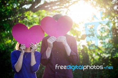 Loving Couple. Beautiful Young Loving Couple Holding Paper Heart… Stock Photo