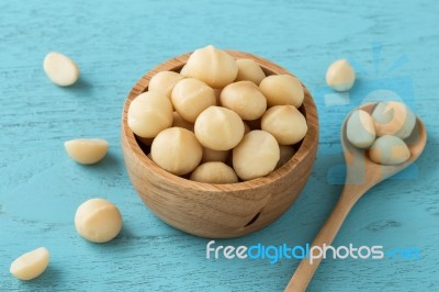 Macadamia In Bowl On Blue Table Stock Photo