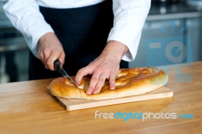 Male Chef Cutting Bread Loaf Stock Photo