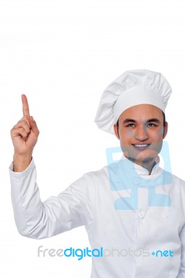 Male Chef Looking And Pointing Upwards Stock Photo