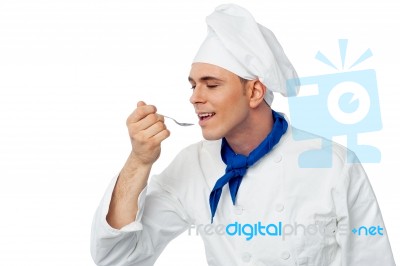 Male Chef Tasting The Food Stock Photo