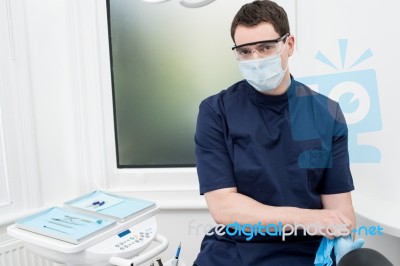 Male Dentist With Tools At Dental Office Stock Photo