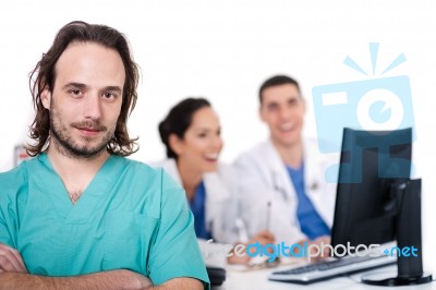 Male Doctor On Focus, Two Doctors Discussing At Background Stock Photo