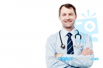 Male Doctor Smiling With Arms Crossed Stock Photo