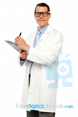 Male Doctor Writing Medical Report Stock Photo