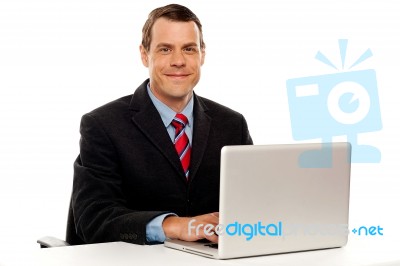 Male Executive At Work Desk Operating Laptop Stock Photo