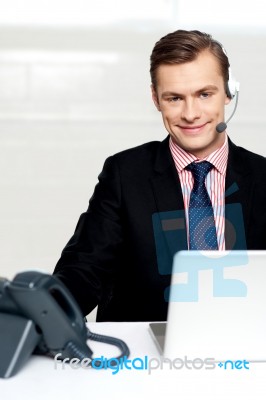 Male Executive Wearing Headsets And Smiling Stock Photo