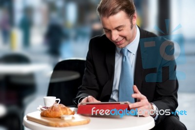 Male Manager Browsing Internet On Tablet Device Stock Photo