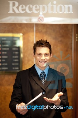 Male Receptionist Holding Paper Stock Photo