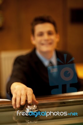 Male Receptionist Pushing Bell Stock Photo