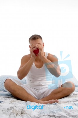 Male Sipping Coffee Sitting On Bed Stock Photo