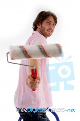 Male Standing On Chair And Showing Paint Roller Stock Photo