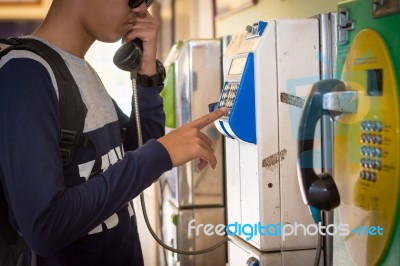 Male Tourists Are Using The Old Public Telephone Keypad Stock Photo