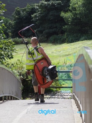 Man Carrying A Lawnmower At Beeston Castle Stock Photo