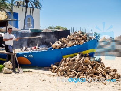 Man Cooking Fish On The Beach In Marbella Stock Photo