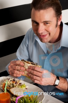 Man Eating Sandwich In A Restaurant Stock Photo