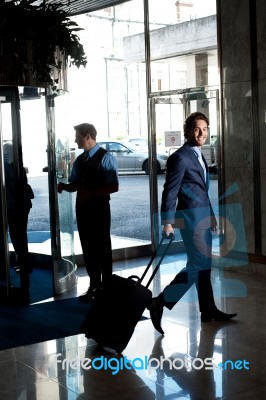 Man Entering Hotel With Luggage Stock Photo